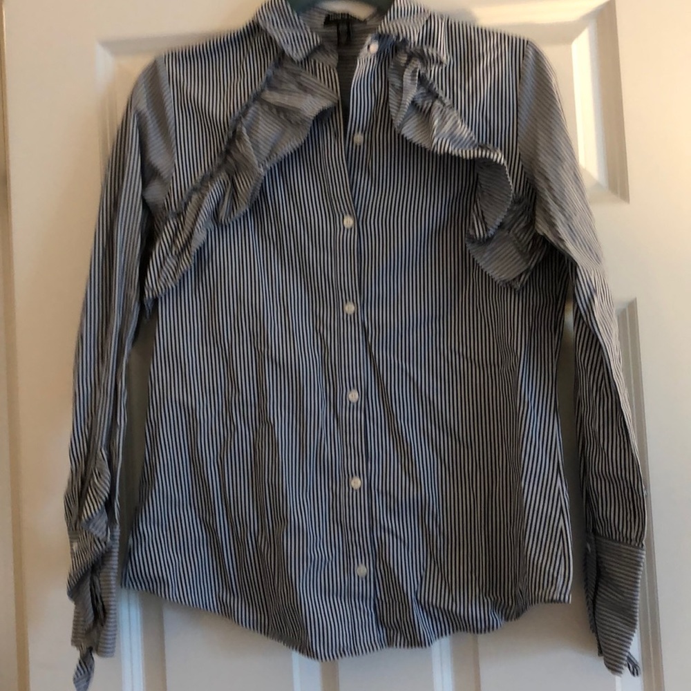Button down blouse, accented with ruffles.